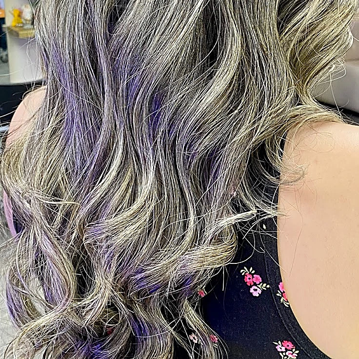Cabello largo con luces claras y puntas lila en ondas sueltas